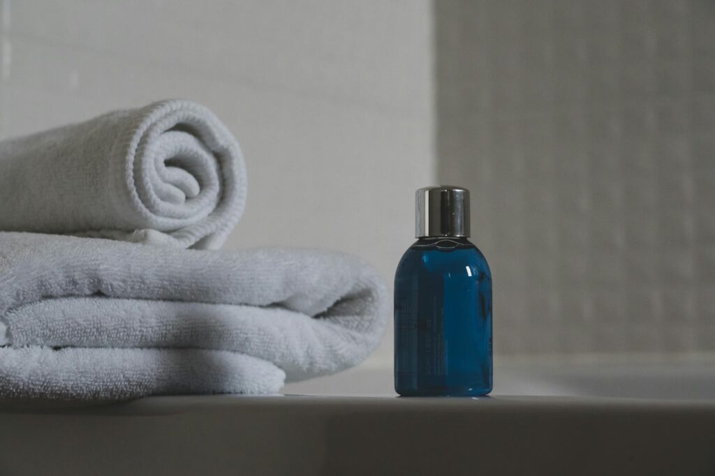 blue glass bottle beside white towel