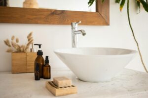 sink with mirror bottles of soap and cosmetic oil in bathroom