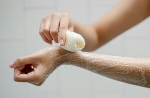 crop person washing arms with soap