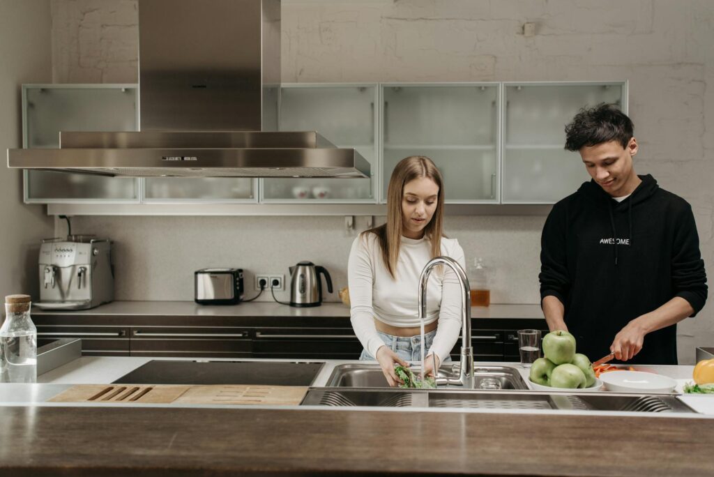 a couple in a kitchen preparing food